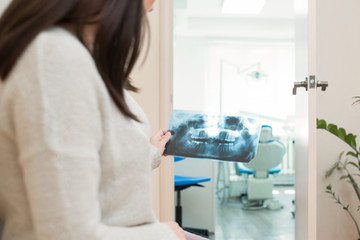 Fototapeta premium Doctor talking with patient and showing a radiograph in stomatology clinic