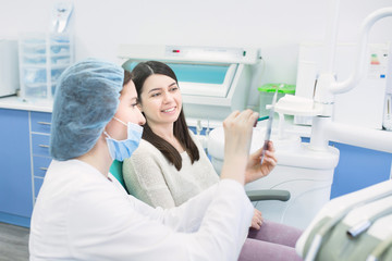 Doctor talking with patient and showing a radiograph in stomatology clinic