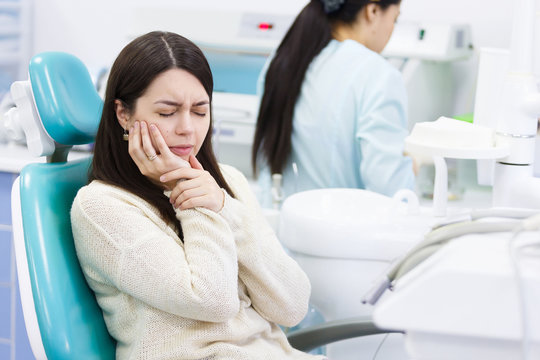 Unhappy patient having a toothache in dental clinic
