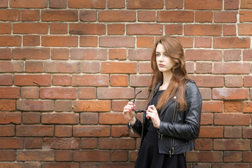 Girl with long hair near an old brick wall