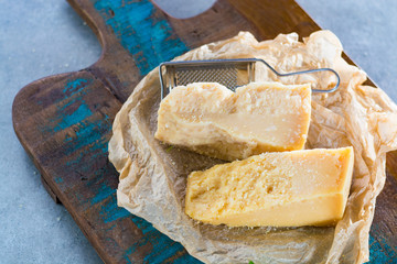 Traditional Italian hard cheese Parmesan and Grana Padano with grater and fresh basil