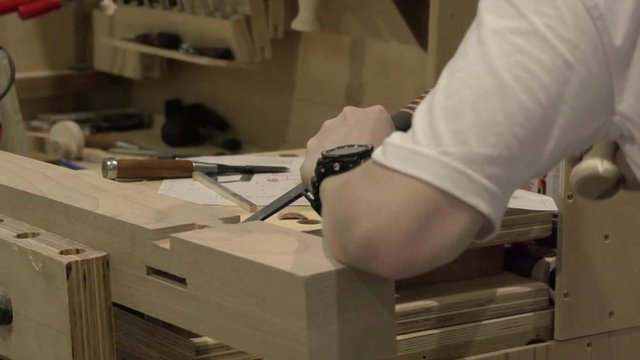 Hands of The Carpenter Work With a Chisel Process a Wooden Detail