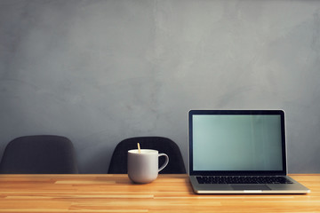 coffee cup and laptop in office table