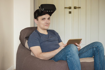 Man plays game with virtual reality glasses indoors