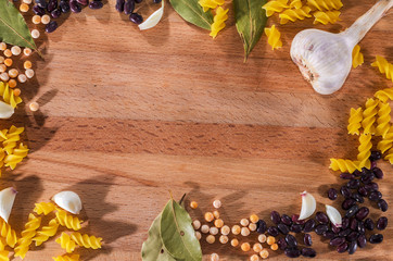 Macaroni and spices on a cutting board, frame, background