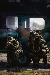 Photos of a group of military men with a gun in front of a helicopter