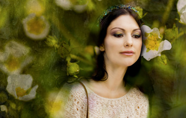 The woman's portrait in flowers of a wild strawberry