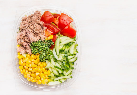 Fresh dieting salad in lunch box on white wooden background , top view