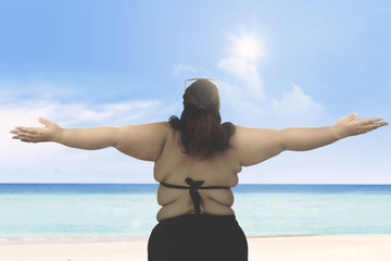 Fat woman wearing swimwear on beach