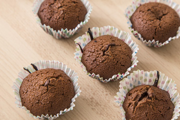 Brown chocolate muffins on a wooden background