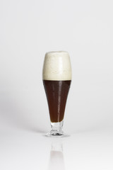 Glass of cold dark beer on a white background isolated