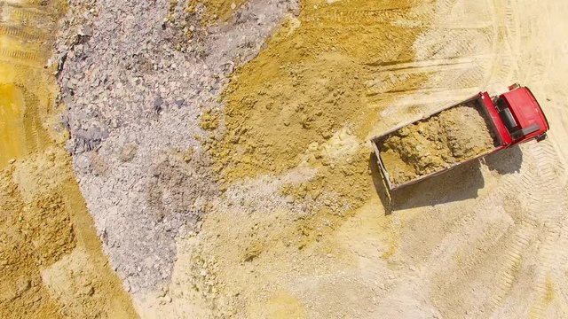 Aerial view of truck on muddy road on a construction site. Heavy industry from above. Industrial background from devastated landscape. 