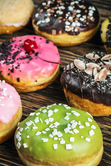 Glazed donuts with different fillings on a wooden table