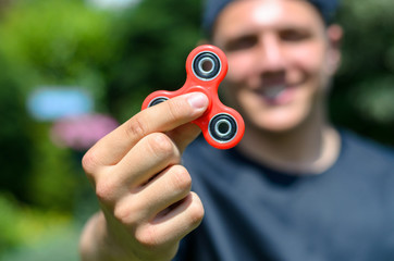 young man playing with a fidget spinner
