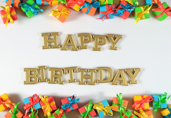Happy birthday golden text and colorful gifts on a white