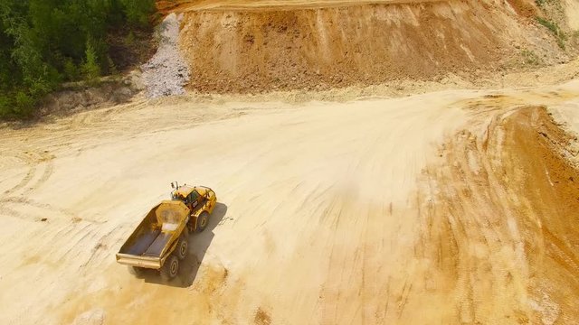 Aerial view of truck on muddy road on a construction site. Heavy industry from above. Industrial background from devastated landscape. 