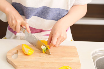 黄パプリカを切る女性

