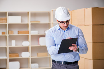 Young worker in the postal office dealing with parcels