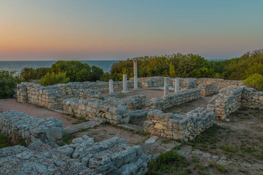 An HDR photo of Basilica inside basilica, museum Chersonesos (Chersonesus) Taurica near Sevastopol, Crimea, Russia. Ancient Byzantine and Greek ruins and columns, and green bushes at the background.