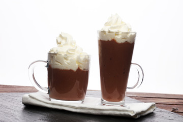 Hot chocolate cocoa with whipped cream on vintage wooden background, selective focus