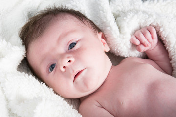 a newborn little baby lying towel