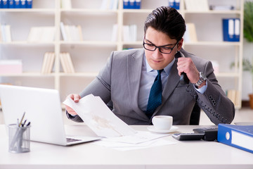 Businessman spilling coffee on important documents