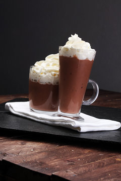 Hot chocolate cocoa with whipped cream on vintage wooden backgro