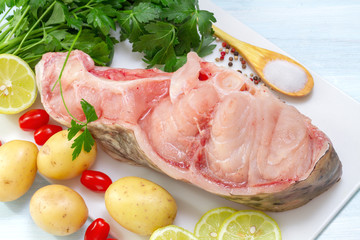 Raw Catfish with herbs and spices on table