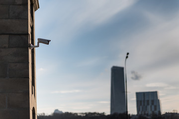 Laterally camera on a stone post in bue sky with white clouds