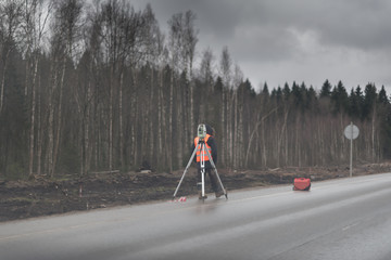 Surveyor engineer is measuring level on construction site.