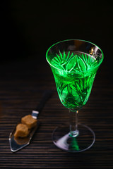 absinthe in  glass and spoon with  brown sugar cubes
