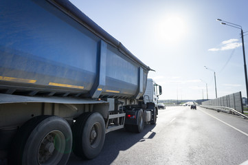 Naklejka na ściany i meble A lorry with tipping trailer in motion on the motorway
