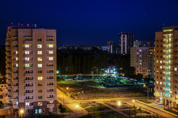 Fototapeta na wymiar City at night with moon in the sky