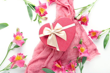 Pink alstroemeria flowers with gauze fabric and gift box on a white background