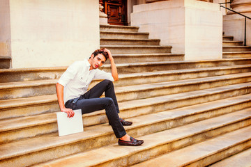 Young Businessman sitting on stairs, relaxing outside