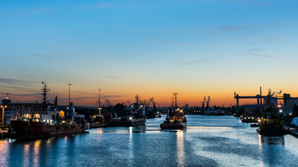 Towboat leaving off a harbor after sunset.