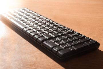 Computer black keyboard on wood background.