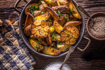 American potatoes. Baked potatoes in peel. Roasted potatoes with garlic spices salt cumin and herbs.