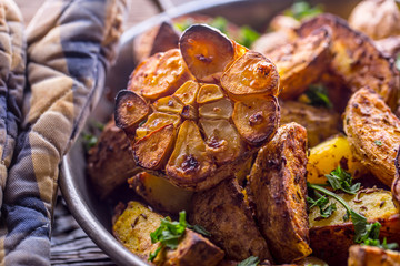 American potatoes. Baked potatoes in peel. Roasted potatoes with garlic spices salt cumin and herbs.