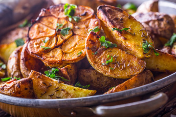 American potatoes. Baked potatoes in peel. Roasted potatoes with garlic spices salt cumin and herbs.
