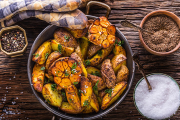 American potatoes. Baked potatoes in peel. Roasted potatoes with garlic spices salt cumin and herbs.
