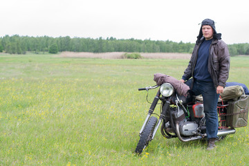 Fototapeta na wymiar A post apocalyptic man on motorcycle in a meadow