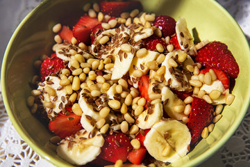 ingredients of a healthy tasty breakfast: strawberries, muesli, banana, flax, pine nuts