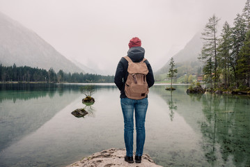 Germany. Lake Hintersee. Girl traveler with a backpack near a high mountain lake in the Alps
