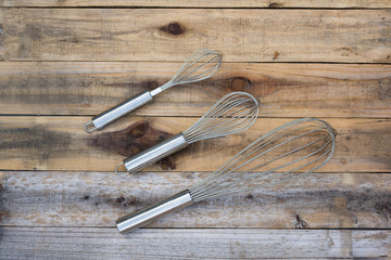 3 whisk กifferent size on wood table