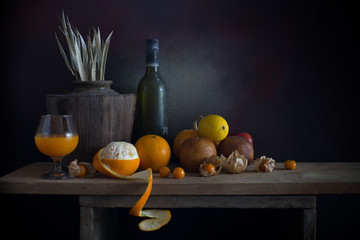 Oranges peel off and other fruits on and old bottle on the plank in dim light night / Still life style  and select focus, space for text.. © tatui1761