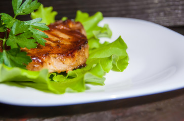Beef steak on lettuce leaves.