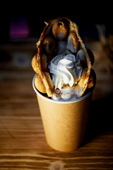 Sweet Hong Kong waffle with fruit and whipped cream in a brown Cup
