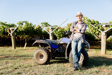 Fototapeta premium Man standing next to truck in vineyard