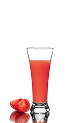 Fresh sliced tomato and a glass of tomato juice, with a mirror image